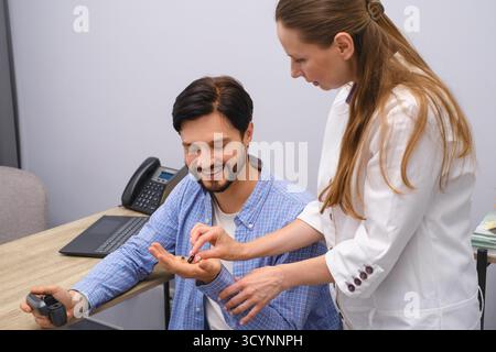 HNO-Arzt zeigt moderne Miniatur-Hörgeräte für den Mann mittleren Alters am modernen medizinischen Zentrum. Audiologe hilft bei der Beurteilung von Hörstörungen Stockfoto