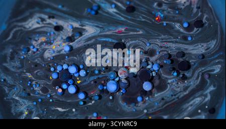 Verschüttete Blasen. Ölmischung. Defokussierter blauer lila roter farbenfroher Glitzer-Textur funkelnder runder Tintentropfen-Kreis auf abstraktem Hintergrund. Stockfoto