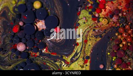 Funkelnde Blasen. Hintergrund malen. Unschärfe gelb lila rot Farbe Glitzer Textur Ölpigment rund flüssiger Kreis auf Acrylabstraktion. Stockfoto