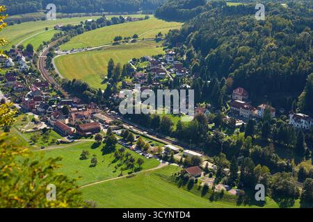 Blick aus der Vogelperspektive auf ein kleines Dorf mit Häusern, Eisenbahn und Feldern umgeben von grünen Feldern, Wäldern und Hügeln in Deutschland. Eine kleine Stadt in der Nähe der Sächsischen Schweiz Stockfoto