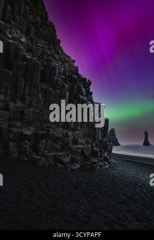 Reynisfjara Basaltsäulen und Reynisdrangar unter aurora Stockfoto