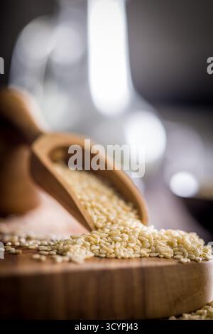 Gebratene Sesamsamen in einer Schaufel auf einem Holztisch. Stockfoto