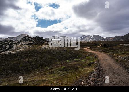 Mossy lava field and trail toward rhyolite mountains, Iceland Stockfoto