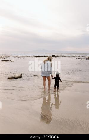 Mutter und Tochter im Meer bei Sonnenaufgang Stockfoto