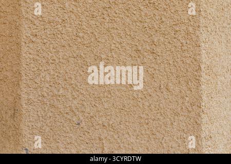 Beige raue Putzwand mit körniger Oberflächenstruktur für Design und Hintergrund. Stockfoto