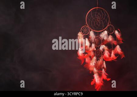 Schöner Traumfänger und Rauch in Farbe hell auf dunklem Hintergrund. Leerzeichen für Text Stockfoto