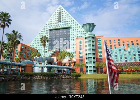Blick auf das Walt Disney World Dolphin Hotel vom Wasser aus mit seiner blauen Pyramidenstruktur und der US-Flagge im Vordergrund Stockfoto