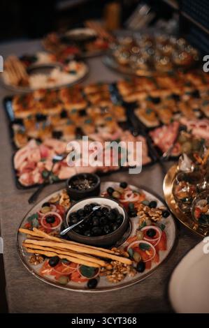 Verschiedene Wurstplatten mit Aufschnitt, Käse, Oliven und Brotstäbchen. Stockfoto