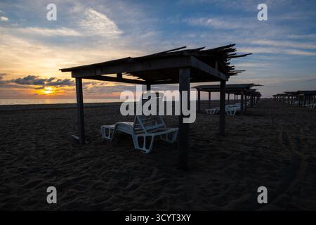 23.09.2024, Albanien, Divjaka, Divjaka - Vordächer für Sonnenschutz und Liegestühle am Strand an der Adriaküste in Divjaka-Karavasta National Stockfoto