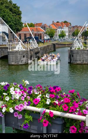 02.07.2025, Niederlande, Zeeland, Middelburg - Bürgerhäuser am Binnenhaven in der Altstadt. Touristen machen eine Bootsfahrt durch die Kanäle der alten Stockfoto
