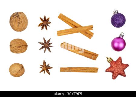 weihnachtsdekoration: Nussbaum, Anisstern, Zimt und weihnachtskugeln in Rot und Lila isoliert auf weiß Stockfoto