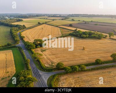Eine Luftaufnahme zeigt Haufen Heuballen in einem Weizenfeld nach der Ernte auf dem Wirral, England. Stockfoto