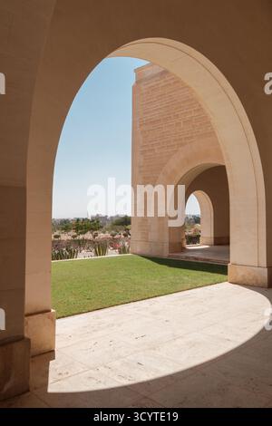 Steinbogenkolonnade mit gepflegtem Garten auf dem Friedhof der Commonwealth war Graves Commission in El Alamein, Ägypten Stockfoto