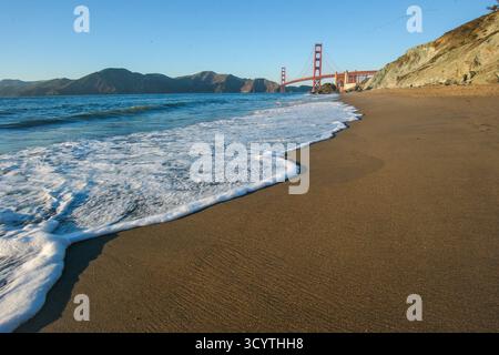 17. OCT 2025 - San Francisco, USA - die Golden Gate Bridge von der westlichen Seite aus gesehen während der Dämmerung vom Marshalls Beach mit Strand und Küste in Th Stockfoto
