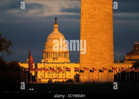 US Capitol Dome und Washington Monument at Sunset Washington DC / WASHINGTON DC – das Washington Monument und der US Capitol Dome sind in goldenem Sonnenuntergangslicht auf der National Mall getaucht. Das Washington Monument, ein Obelisk aus Marmor, Granit und Blausteingneis, ist 169,29 Meter (555 Fuß 5 1/8 Zoll) hoch. Der Kapitoldom der USA wird von der Bronzestatue of Freedom gekrönt, einer allegorischen Figur. Diese legendären Bauten liegen zentral in der National Mall, einem bedeutenden Nationalpark im Herzen von Washington DC. Stockfoto