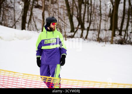 Ein erfahrener bärtiger Mann genießt das Snowboarden auf einer verschneiten Piste und zeigt seinen Wintergeist. Stockfoto