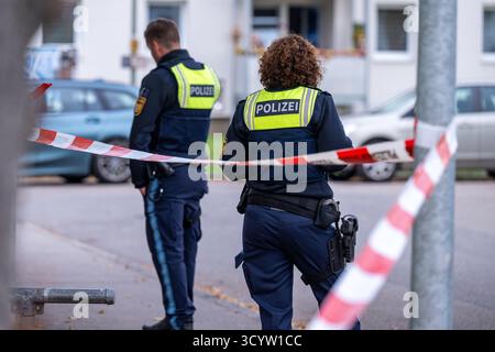 Landshut, Deutschland. Oktober 2025. Polizisten stehen an einem Tatort am Cordon. Nach einem Angriff eines Mannes mit einem Messer schossen zwei Polizisten auf den Mann. Wie viele Schüsse anfangs abgefeuert wurden, blieb unklar, ebenso wie die Frage, ob der Mann getroffen wurde. Die beiden Polizisten und der 30-jährige Angreifer seien jedoch während der Operation verletzt worden, so die Polizei. Quelle: Armin Weigel/dpa/Alamy Live News Stockfoto
