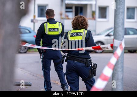 Landshut, Deutschland. Oktober 2025. Polizisten stehen an einem Tatort am Cordon. Nach einem Angriff eines Mannes mit einem Messer schossen zwei Polizisten auf den Mann. Wie viele Schüsse anfangs abgefeuert wurden, blieb unklar, ebenso wie die Frage, ob der Mann getroffen wurde. Die beiden Polizisten und der 30-jährige Angreifer seien jedoch während der Operation verletzt worden, so die Polizei. Quelle: Armin Weigel/dpa/Alamy Live News Stockfoto