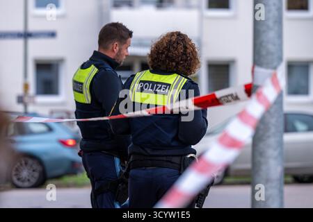 Landshut, Deutschland. Oktober 2025. Polizisten stehen an einem Tatort am Cordon. Nach einem Angriff eines Mannes mit einem Messer schossen zwei Polizisten auf den Mann. Wie viele Schüsse anfangs abgefeuert wurden, blieb unklar, ebenso wie die Frage, ob der Mann getroffen wurde. Die beiden Polizisten und der 30-jährige Angreifer seien jedoch während der Operation verletzt worden, so die Polizei. Quelle: Armin Weigel/dpa/Alamy Live News Stockfoto
