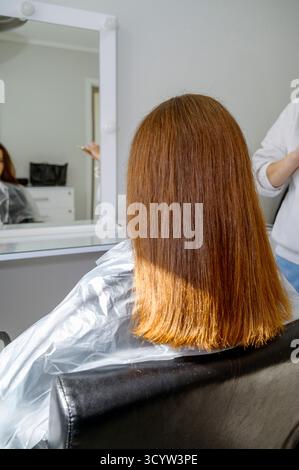 Eine Person, die vor einem Spiegel steht und für die Kamera posiert Stockfoto