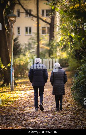 Berlin, Deutschland. Oktober 2025. Ein älterer Mann und eine Frau machen einen Spaziergang durch einen Park in der Morgensonne, fotografiert in Berlin, 20. Oktober 2025. Quelle: dpa/Alamy Live News Stockfoto