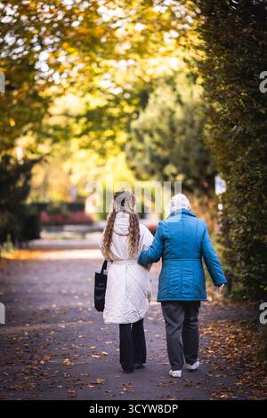 Berlin, Deutschland. Oktober 2025. Eine junge Frau und eine Seniorin machen einen Morgenspaziergang durch einen Park, fotografiert in Berlin am 20. Oktober 2025. Quelle: dpa/Alamy Live News Stockfoto