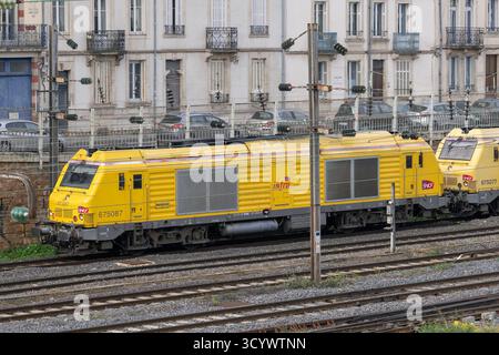 Nancy, Frankreich - Blick auf eine gelbe dieselelektrische Lokomotive Alstom - Siemens BB 75000 überquert den Bahnhof Nancy. Stockfoto
