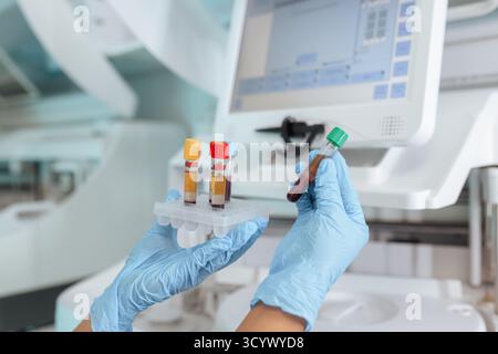 Labortechnikerin, die Reagenzgläser mit Blutproben in einem biochemischen Zentrifugenanalysator platziert. Wissenschaft und Medizin. Stockfoto
