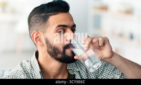 Mann genießt tagsüber drinnen ein erfrischendes Getränk Stockfoto