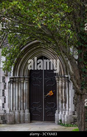 Blick durch einen Baum auf eine alte Bogentür der St. Mary's Church, auch bekannt als die Kirche der Heiligen Maria der Jungfrau, in der Stadt Dover, Kent, England, Großbritannien Stockfoto