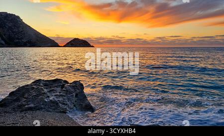 Genießen Sie die Meereslandschaft bei Sonnenuntergang am malerischen Petani Beach in Kefalonia, Griechenland Stockfoto