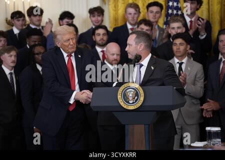 US-Präsident Donald Trump schüttelt die Hand mit Jay Johnson, Head Coach der LSU Tigers, während er am 20. Oktober 2025 an einem Besuch der LSU und LSU Shreveport Baseball Champions im East Room des Weißen Hauses in Washington, DC, USA, teilnimmt. Guthaben: Yuri Gripas/Pool über CNP/MediaPunch Stockfoto
