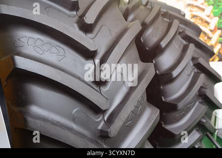 Neue Traktorreifen mit großem Profil in der Nahaufnahme des Ausstellungsraums. Industrie Stockfoto