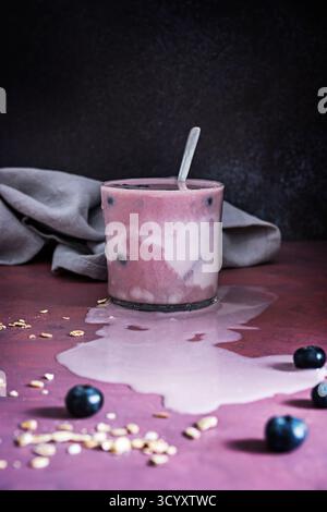Schüssel mit perfekten Blaubeeren und einem Heidelbeeren- und Spinat-Smoothie auf einem hellen, leuchtenden Ahornbrett Stockfoto