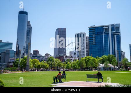 Blick auf die Innenstadt von Atlanta vom Centennial Olympic Park mit SkyView Riesenrad, modernen Wolkenkratzern und entspannenden Besuchern an einem sonnigen Tag Stockfoto
