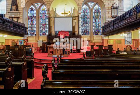 GREENOCK, SCHOTTLAND - 19. August 2024: Innenraum des historischen Wellpark Mid Kirk of Greenock, mit leuchtendem Buntglas, einem Schiffsmodell, einer Pfeifenorgel, Stockfoto
