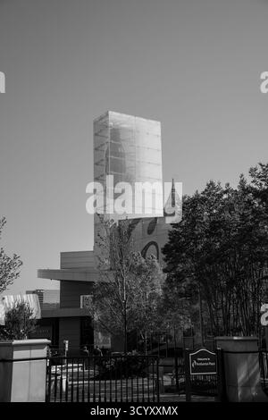Der Glasturm von Coca-Cola erhebt sich am Pemberton Place über der World of Coca-Cola, eingerahmt von Bäumen und einem klaren blauen Himmel in Schwarz-weiß Stockfoto