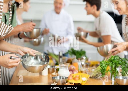 Metallschale mit Sauce, die von den Händen der jungen Frau gemischt wird Stockfoto