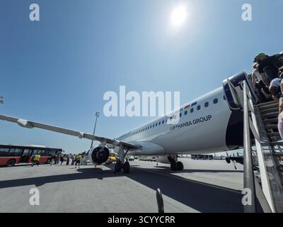 MÜNCHEN, DEUTSCHLAND - 21. JUNI 2025: Lufthansa Group setzt am Flughafen München ein Lufthansa-JET, als Passagiere über eine Treppe einsteigen. Lufthansa ist deutschlands Flagge Stockfoto