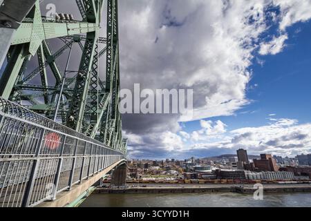 Blick auf die Jacques Cartier Bridge mit einem Stahlfachwerk und Geländer im Vordergrund und den Hafen von Montreal in kanada am Saint Lawrence River, auf tran Stockfoto