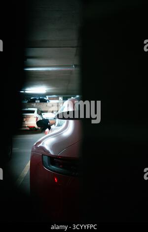Roter Sportwagen in schwach beleuchteter Tiefgarage Stockfoto