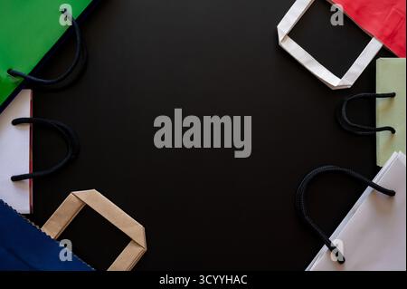 Black Friday Concept mit bunten Einkaufstaschen mit Griffen und dunklem Hintergrund für Verkauf und Werbeaktionen. Stockfoto