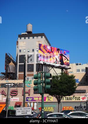 Spider-man über die Spider-Vers-Werbetafel an einem sonnigen Tag in New York City mit blauem Himmel und Wasserturm Stockfoto