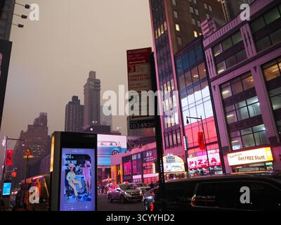 Die beschauliche New York City Street mit Neonschildern und Gebäuden während des kanadischen Waldbrandrauchs im Jahr 2023 Stockfoto