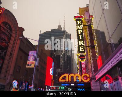 Neonlichter des AMC Empire Theaters leuchten während des kanadischen Lauffeuer in New York City durch rauchigen Dunst am Times Square Stockfoto