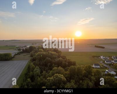 Bergnicourt, Rethel, Ardennes, Grand-Est, Frankreich, am 28. August 2025 erleuchtet Ein atemberaubender Sonnenuntergang die weiten Felder und eine dichte Baumlinie am Horizont während der Abenddämmerung Stockfoto
