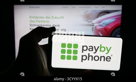 In dieser Abbildung befindet sich ein Mobiltelefon mit dem Logo des kanadischen Parkapp-Unternehmens PayByPhone auf dem Bildschirm vor der Webseite. Stockfoto