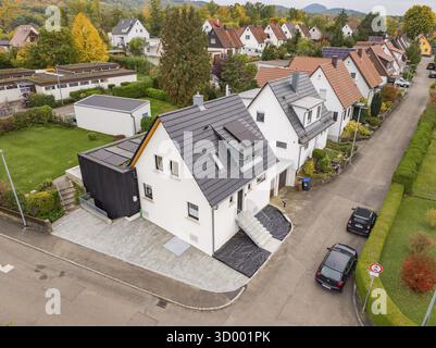 Blick aus der Vogelperspektive auf eine ruhige Wohnstraße mit modernisiertem Haus und Anbau, eingebettet in Herbstgärten, Hausrenovierung, Klimarenovierung, Metzin Stockfoto