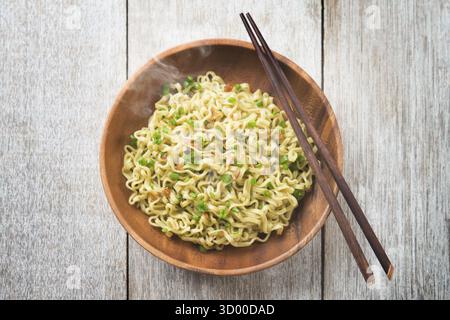 Blick von oben auf gekochte japanische Ramen getrocknete Nudeln mit Essstäbchen auf Holztisch Stockfoto