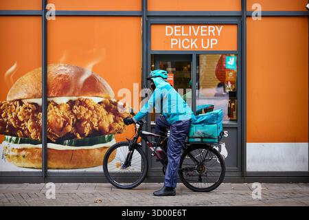 Deliveroo Radfahrer bei Manchester Piccadilly Lieferfenster für die Abholung eines Popeyes Stockfoto
